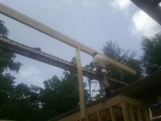 Carpenter setting a ridge beam over a new addition frame — Ice Dam Removal by Roofing Brothers in Dobson