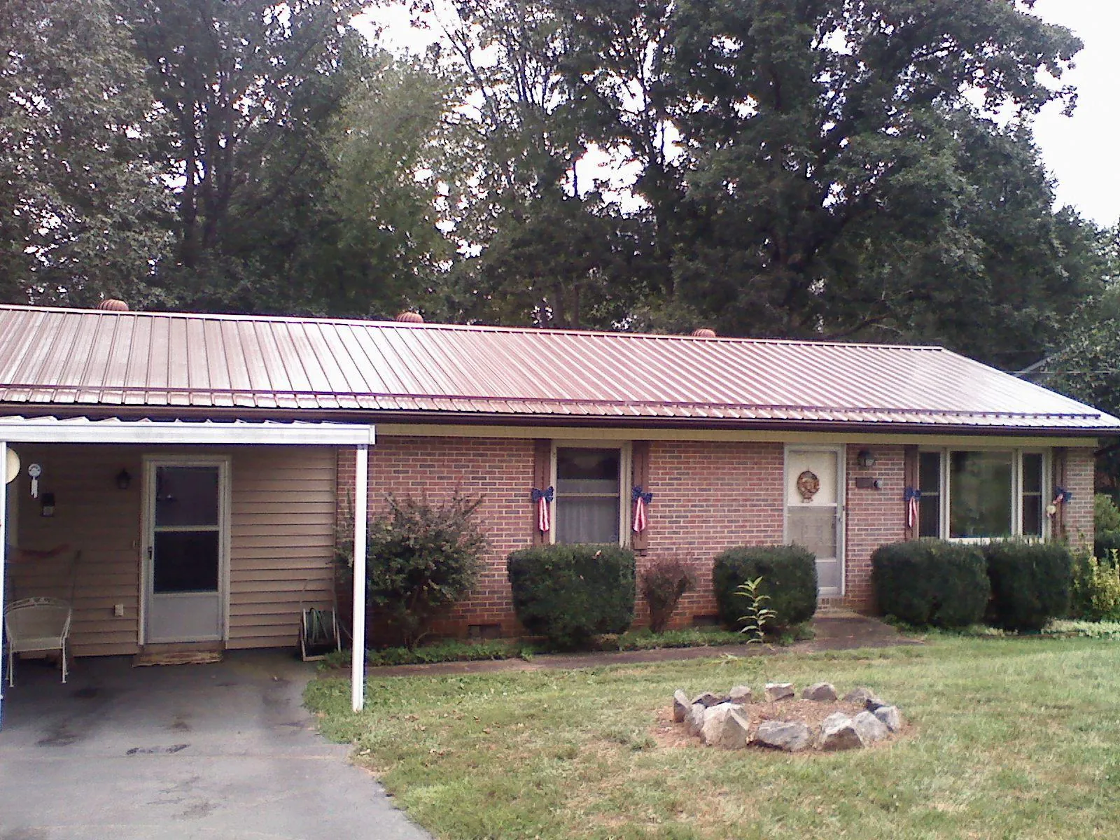Bronze metal roof and carport on a brick ranch home — Roof Repair work by our crew in Dobson