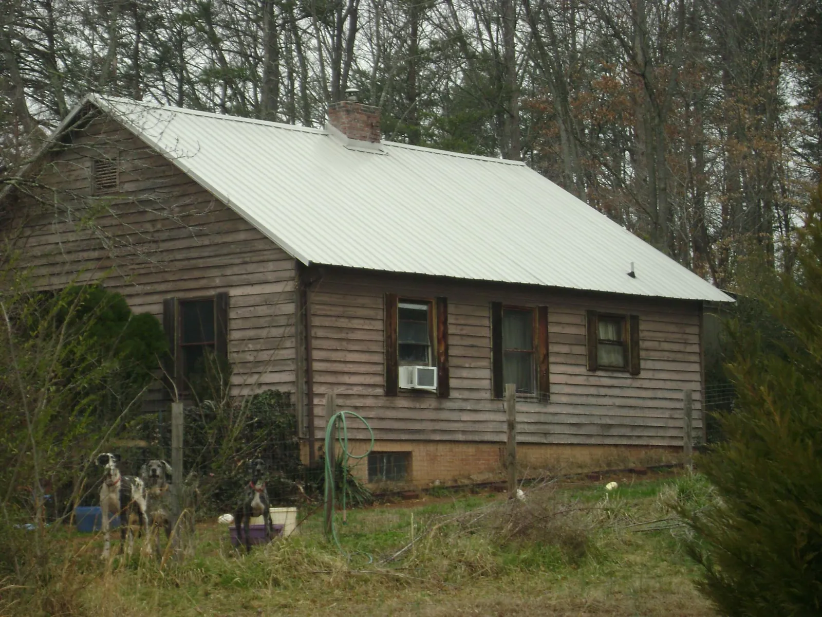 White metal roof on an old wood sided farmhouse, from a Metal Roof Installation job in Dobson